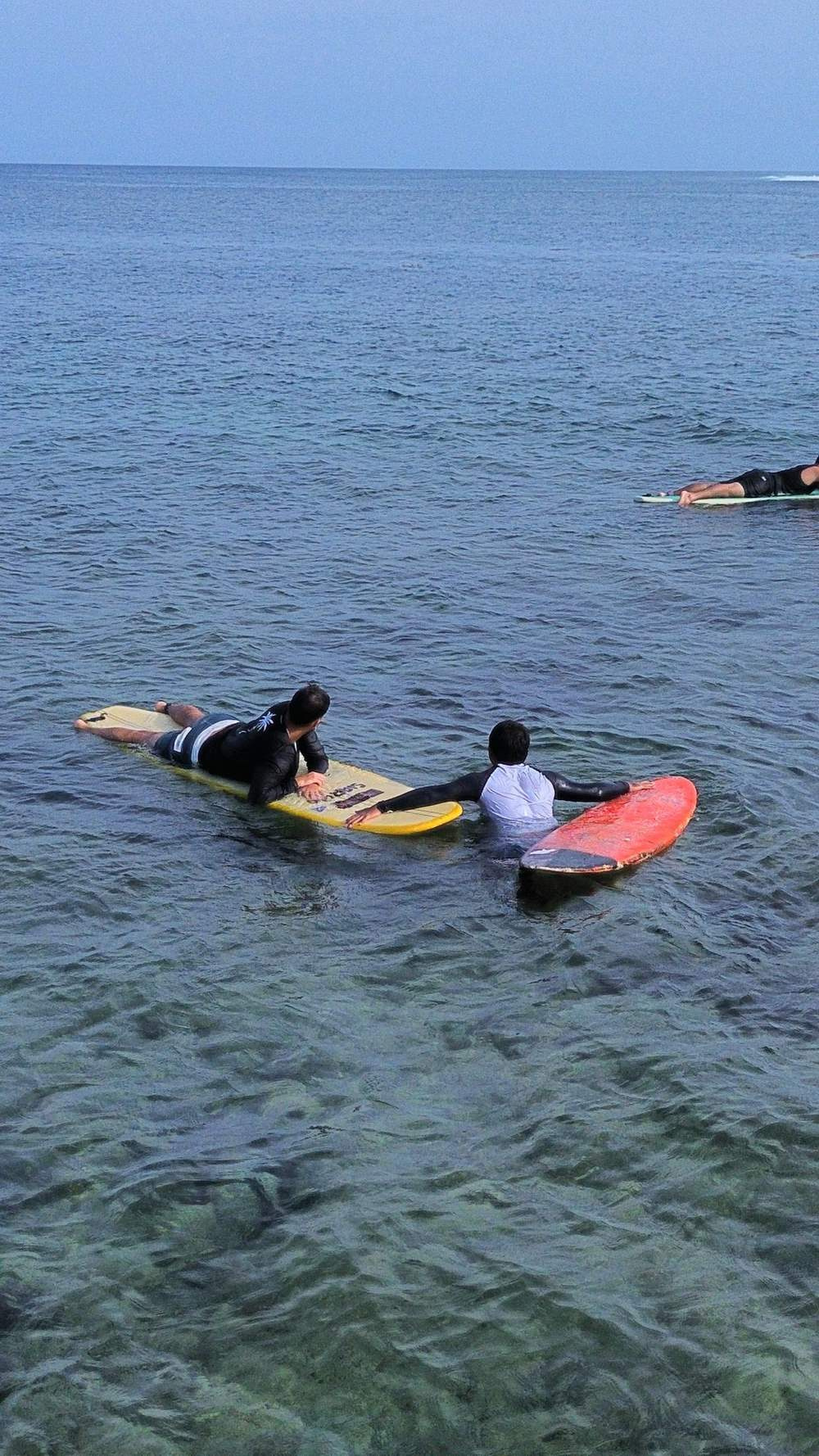Coach pushing a student into a wave
